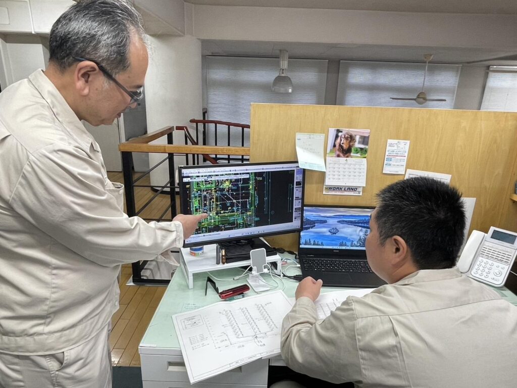 図面を確認する矢口電気の社員